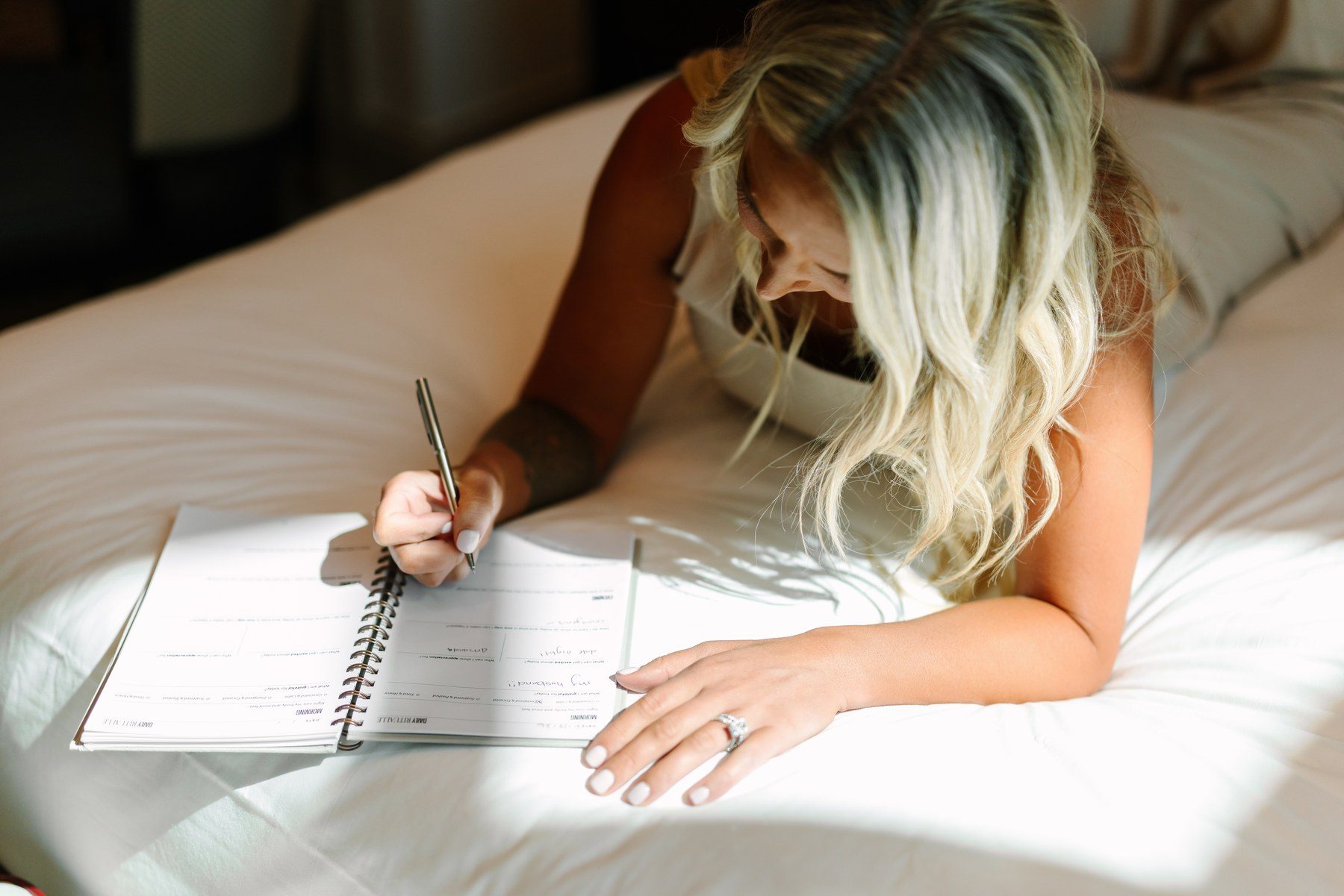 Alex writing in the Bedside Journal on her bed