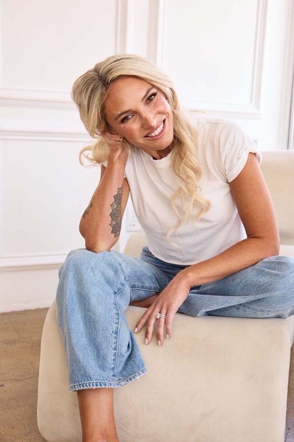 Alex Payetta smiling on a cream chair
